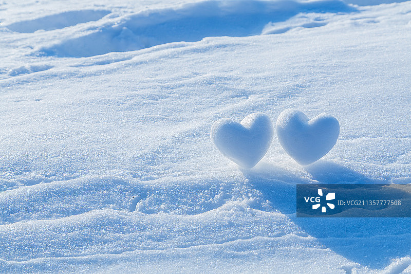 雪地上的两个心形雪球，情人节主题图片素材