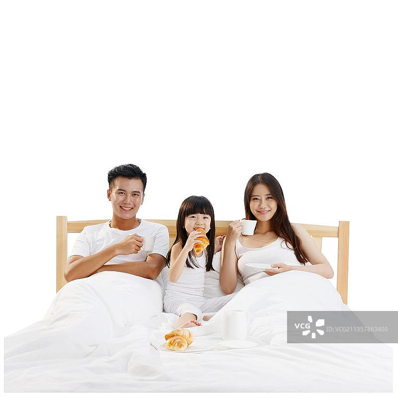 幸福的一家三口在床上吃早餐图片素材