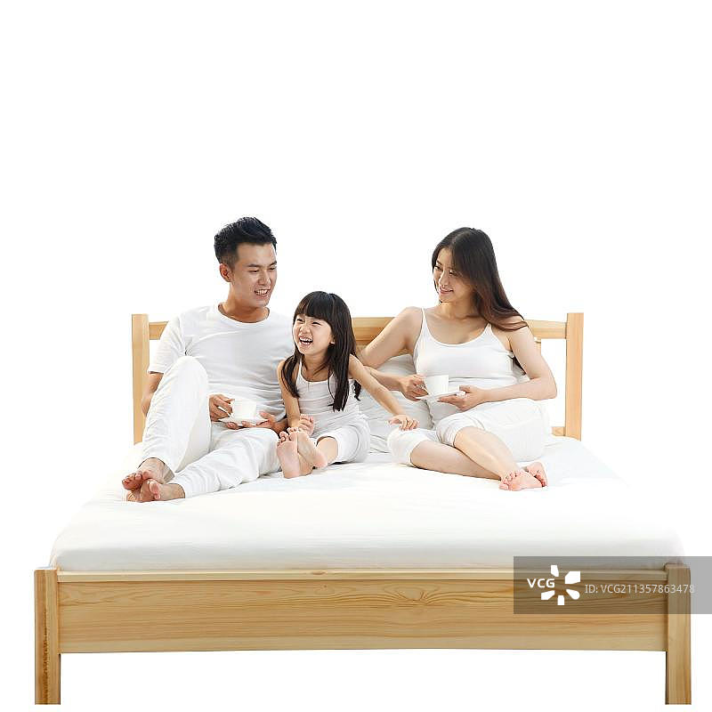 欢乐的一家三口在卧室的床上图片素材