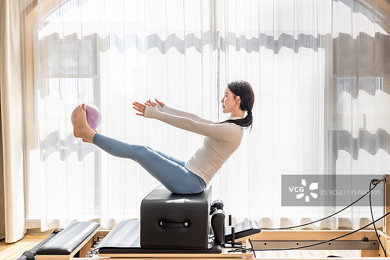 年轻女性在室内做普拉提动作图片素材