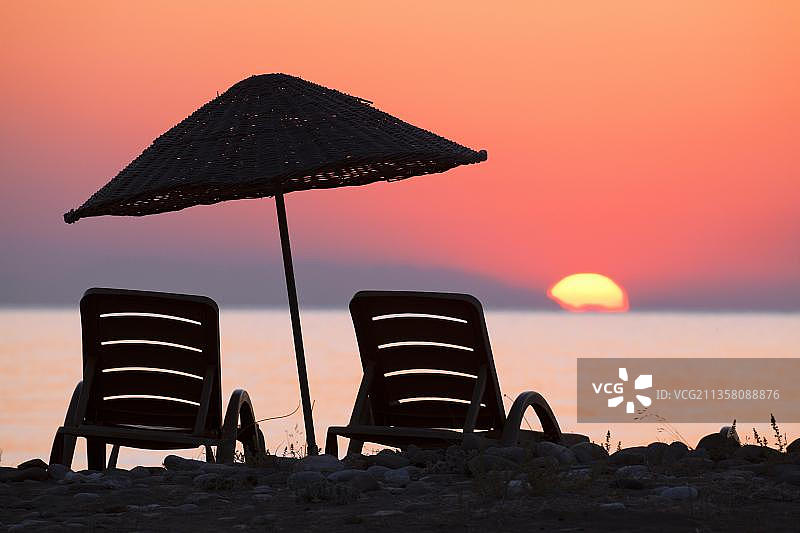 地中海海滩日出时的沙滩椅和遮阳伞图片素材