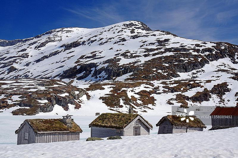 冬季荒凉山地景观中的复古小木屋图片素材