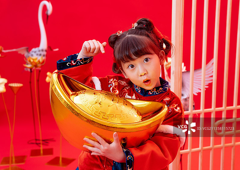 新年小女孩抱着金元宝图片素材