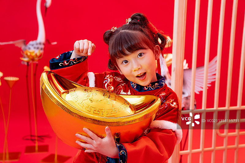 新年小女孩抱着金元宝图片素材