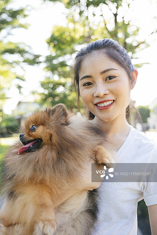 美丽的亚洲主人和波美拉尼亚斯皮兹狗的特写。图片素材