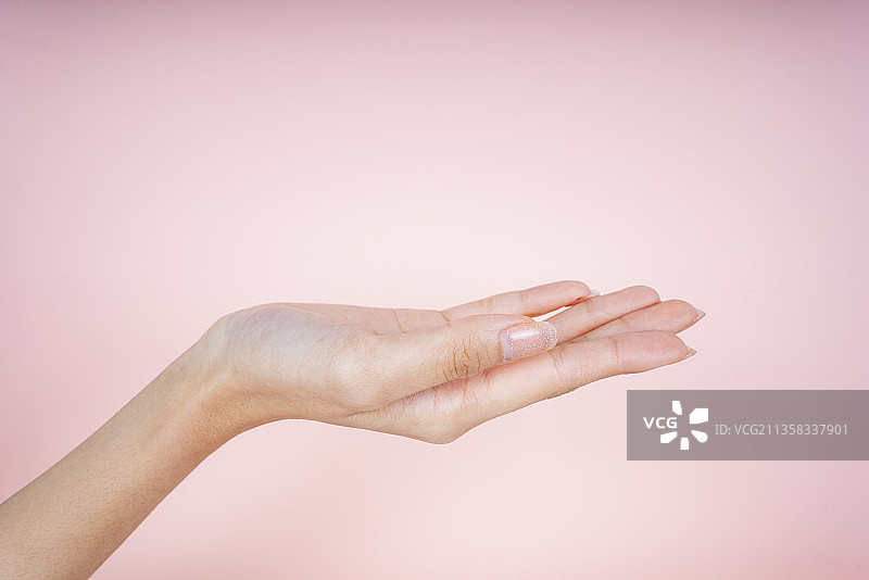 美丽的女人徒手孤立在粉红色的背景。图片素材