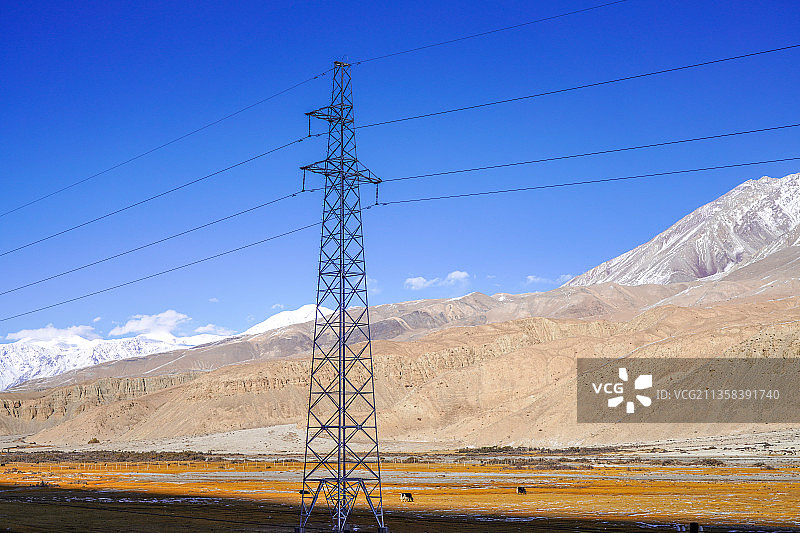 新疆帕米尔高原，雪山草原上的电力输电线，输电塔，电力设施设备图片素材