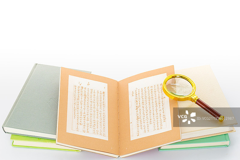 白色背景里放着一堆书和一个放大镜图片素材