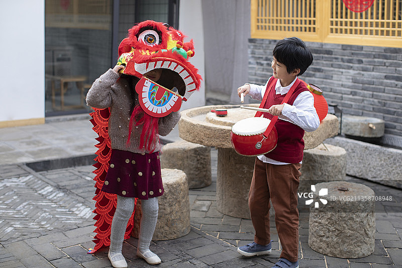 快乐的兄妹俩在院子里舞狮子图片素材