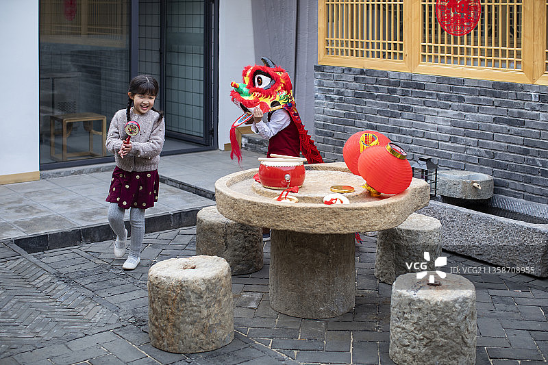 快乐的兄妹俩在院子里舞狮子图片素材