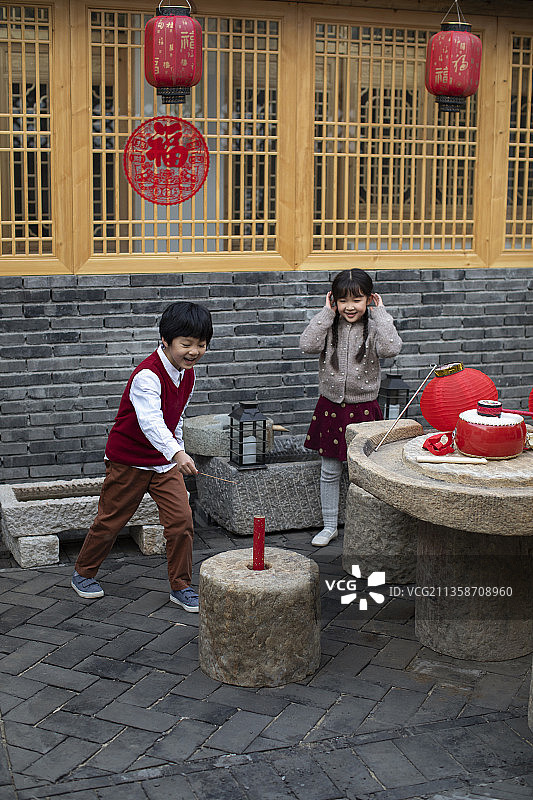 快乐的兄妹俩点爆竹迎新年图片素材