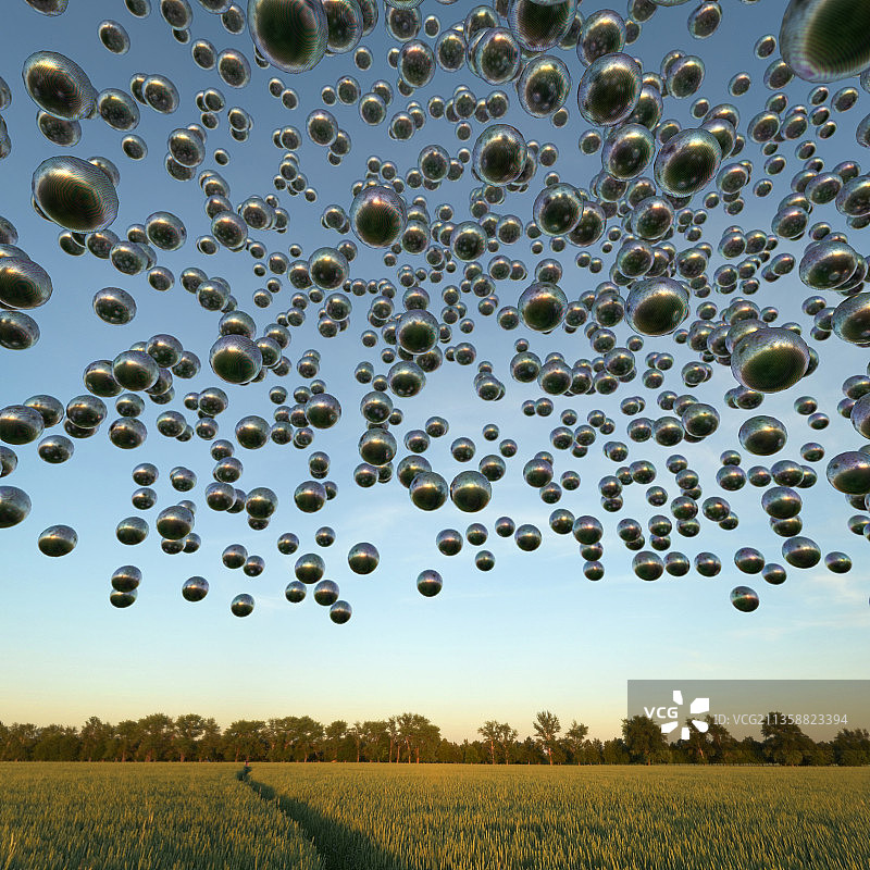 漂浮在农田上方的金属球体图片素材
