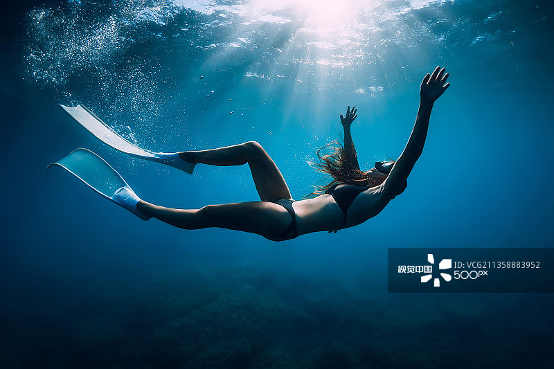 年轻女子在海中游泳的水下视角图片素材