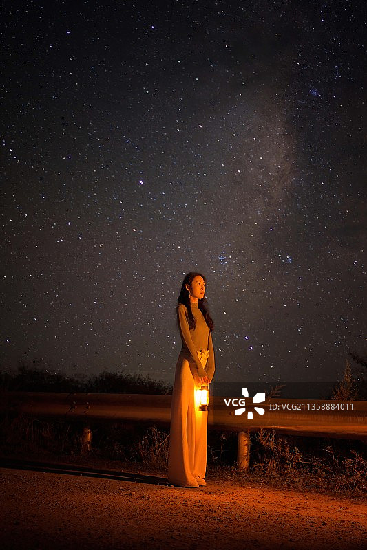 站在中国汉源县的田野上，背景是夜空星空的女人图片素材