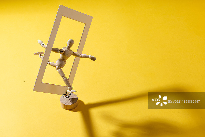 木头小人跳起穿过方框图片素材