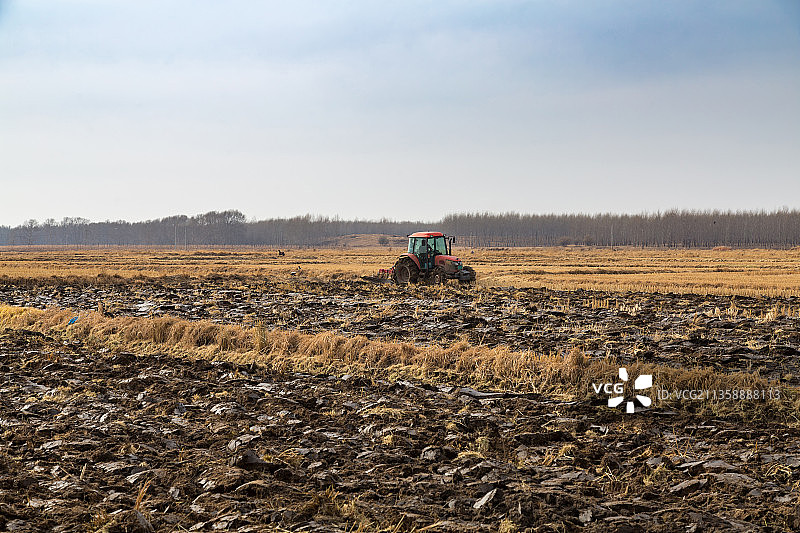 秋天田地里深耕的拖拉机图片素材