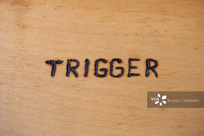 手写在裸露胶合板表面的“TRIGGER”字样图片素材