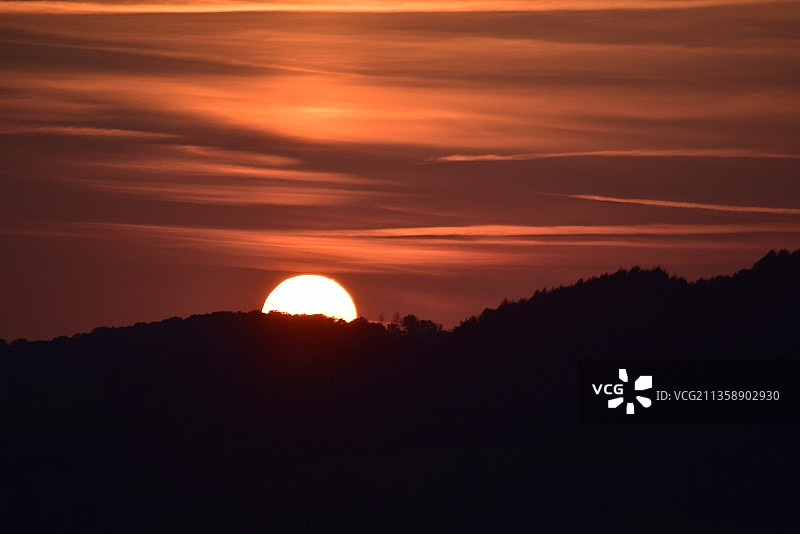 橘黄色天空映衬下群山剪影的风景图片素材