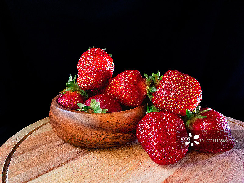 黑背景下，桌上碗中草莓特写，俄罗斯图片素材
