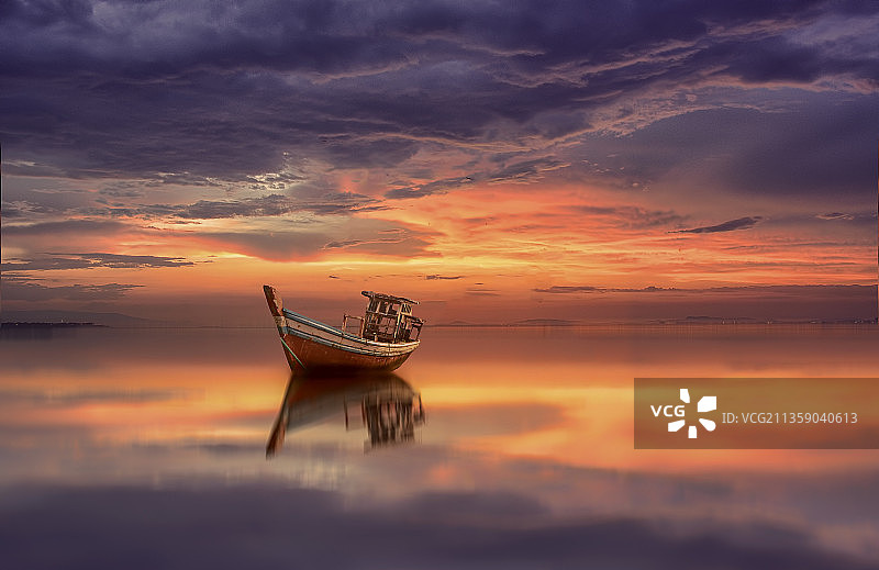 日落时分，天空中海中船只的剪影图片素材