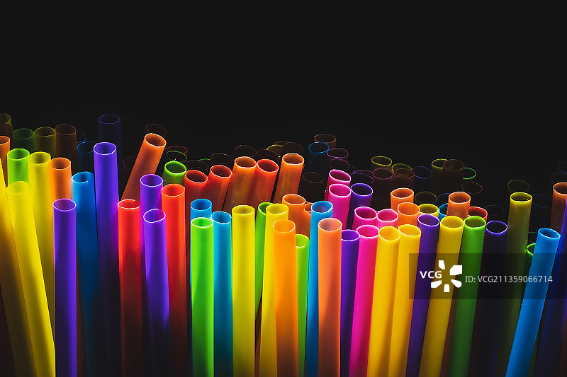 黑色背景下的彩色吸管特写图片素材