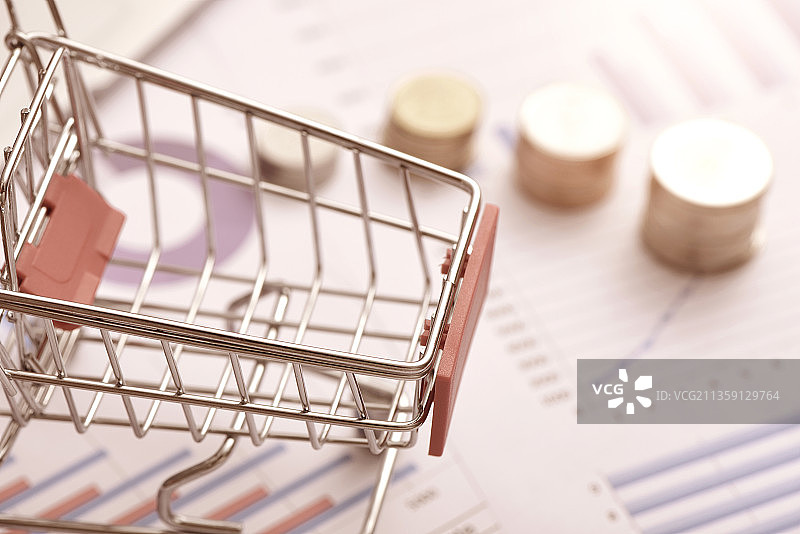 数据图纸上的硬币和购物车图片素材