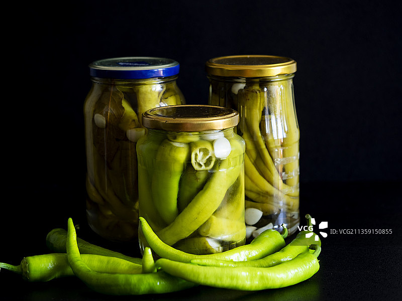 黑色背景玻璃罐中的自制腌辣椒图片素材