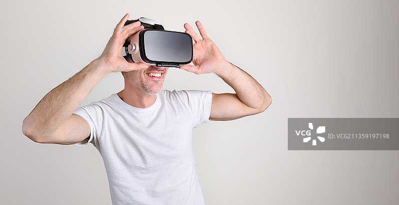 在白色背景下佩戴虚拟现实模拟器的男人图片素材