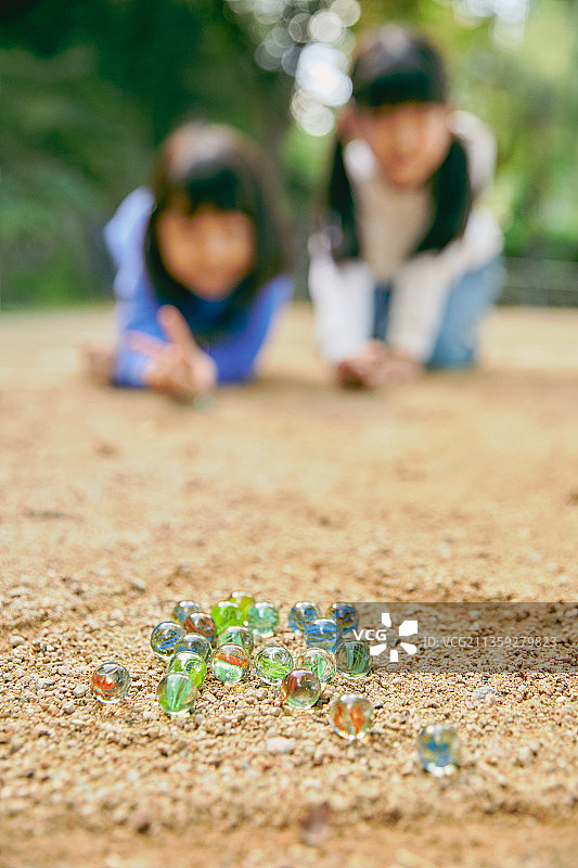 儿童玩耍玻璃球，女孩微笑图片素材