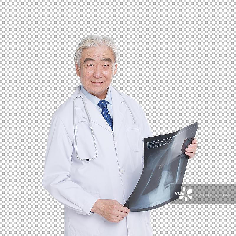 穿着医护服的老年医生拿着X光片图片素材