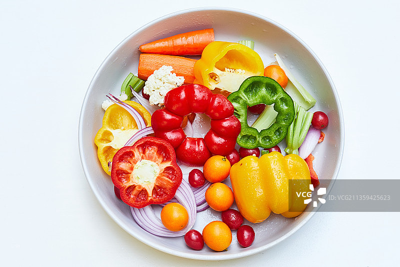 圆形餐盘上的色彩丰富明快的绿色有机素食蔬菜水果图片素材