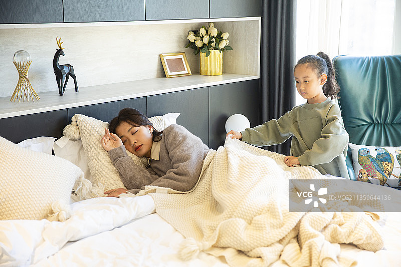 女儿给睡觉的妈妈盖毯子图片素材