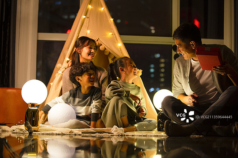 一家四口在客厅露营送礼物图片素材