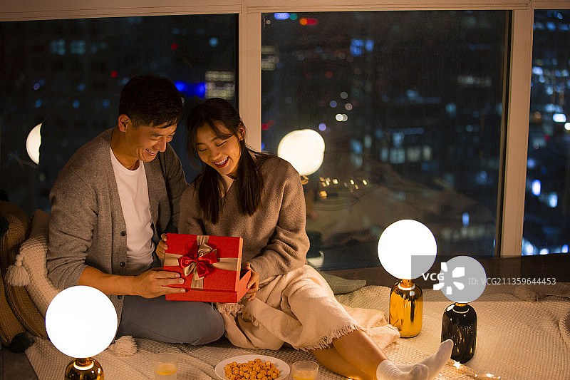 甜蜜情侣在客厅约会送礼物图片素材