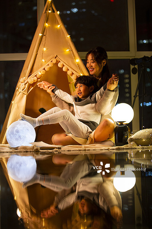 快乐母子在客厅搭帐篷露营张开手臂嬉戏玩耍图片素材