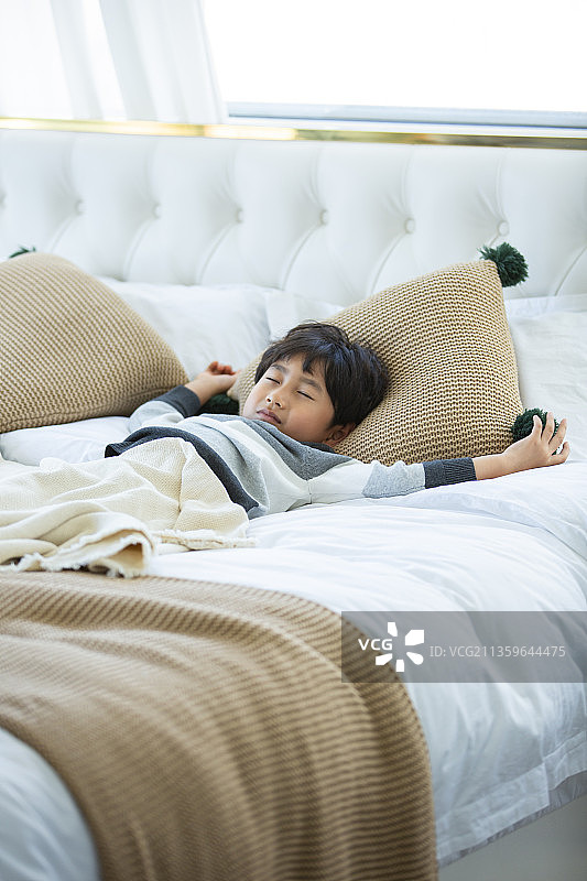小男孩在卧室床上睡觉图片素材