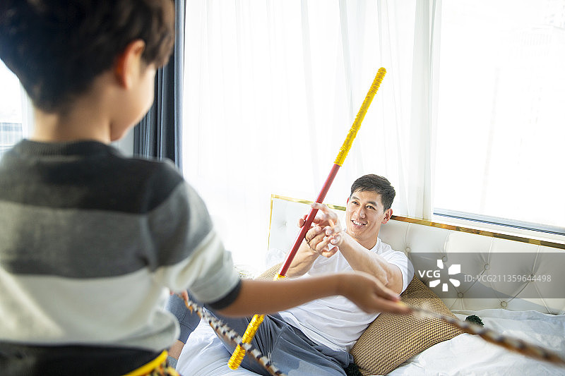 爸爸和儿子装扮孙悟空在卧室玩耍图片素材