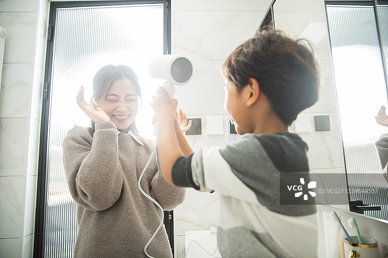 快乐母子在卫生间吹头发图片素材