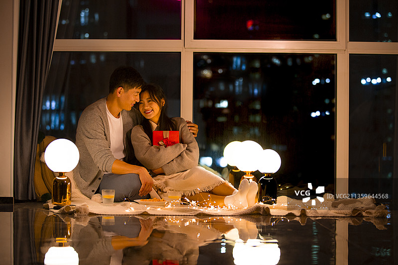 甜蜜情侣在客厅约会送礼物图片素材
