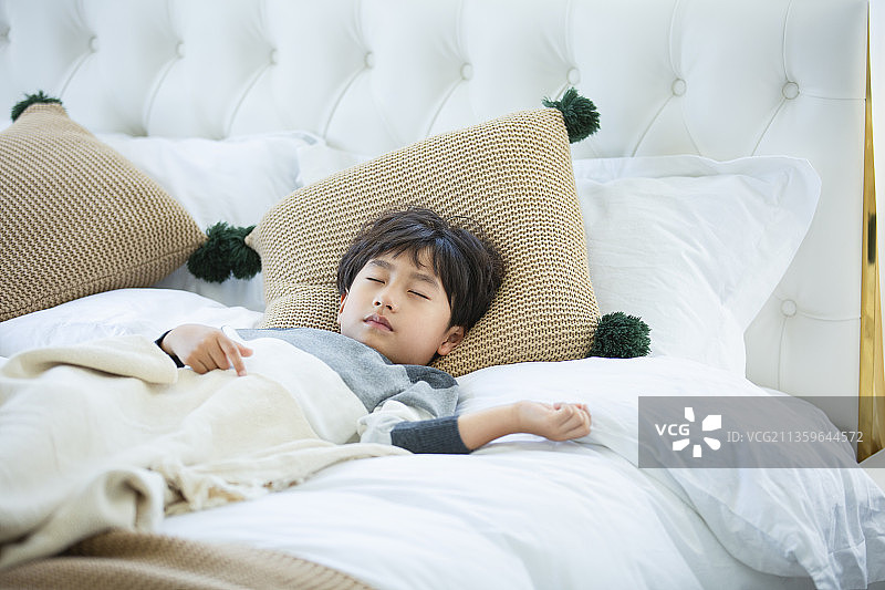 小男孩在卧室床上睡觉图片素材
