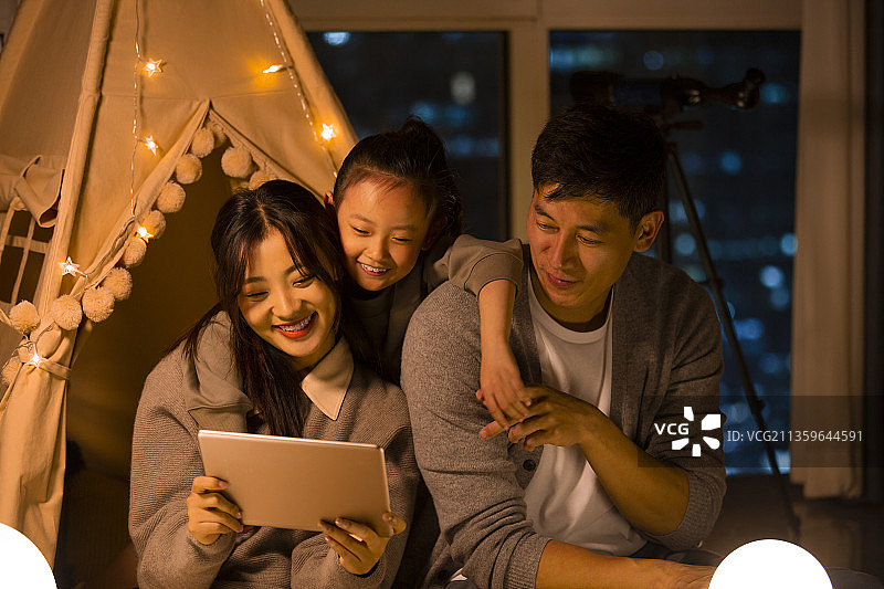 一家三口在客厅露营看平板电脑图片素材