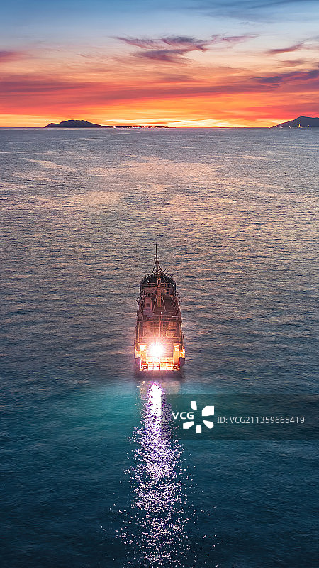 黄昏的三亚湾海平面上一艘远航的船图片素材