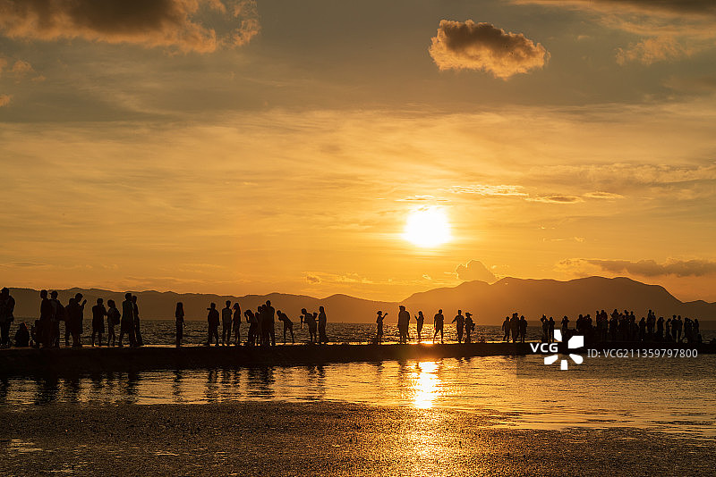 日落时人们在天空的映衬下剪影图片素材
