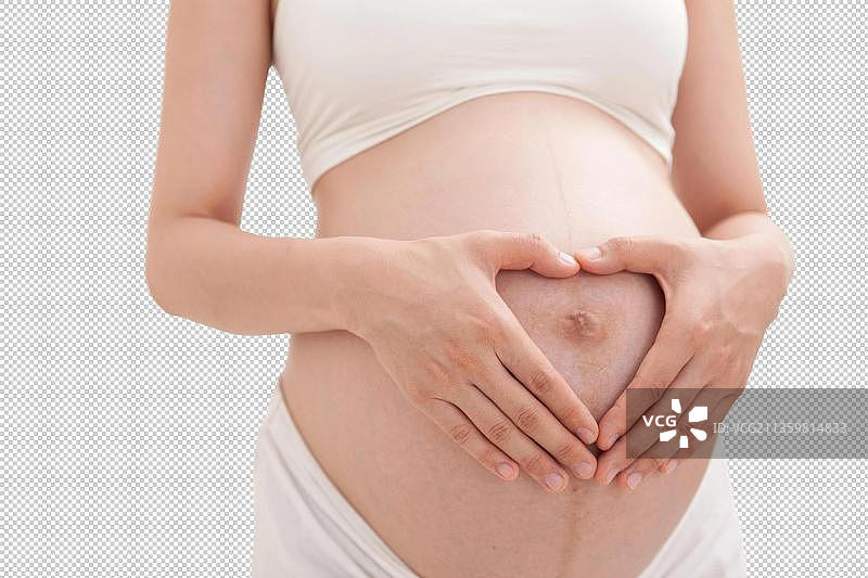 孕妇在肚子上做心型的手势图片素材