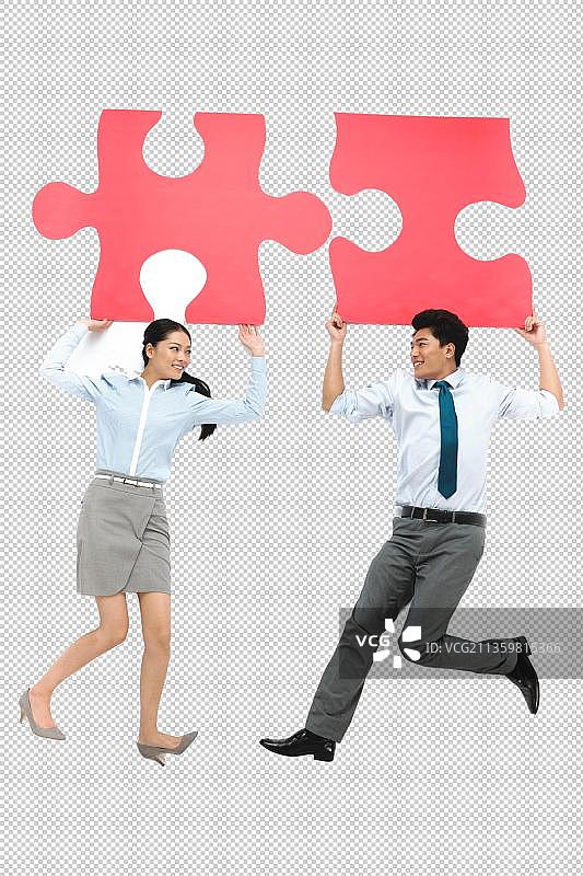 商务男人和女人举着拼图拼块图片素材