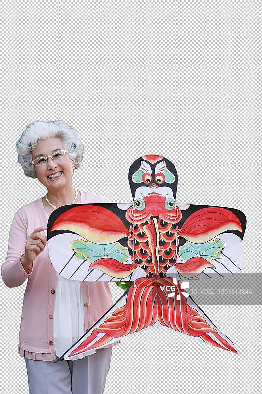 一个老年女人拿着风筝图片素材