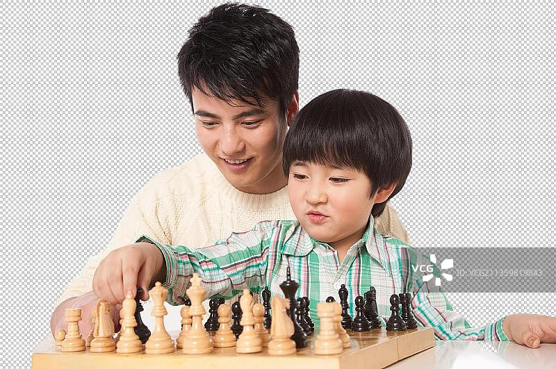 父亲正在指导儿子下国际象棋图片素材