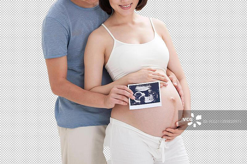 年轻夫妇拿着胎儿B超照片图片素材