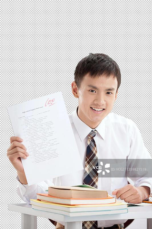 一个中学男生展示试卷在教室里图片素材