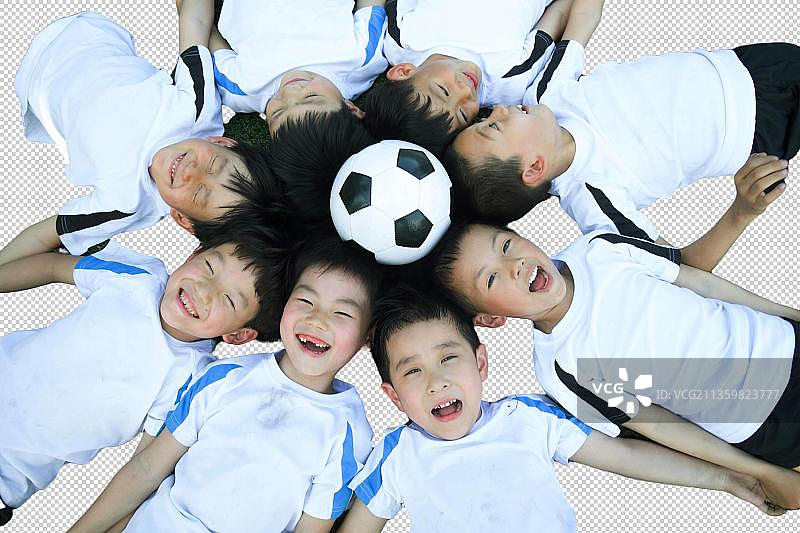 儿童头顶着球躺在足球场上图片素材